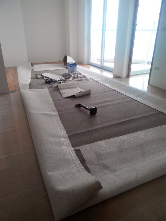 Tiến hành quết keo lên thảm và đợi để keo khô bớt lại